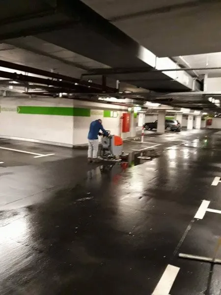 Maschinelle Bodenreinigung in einer Tiefgarage durch einen Gebäudereiniger