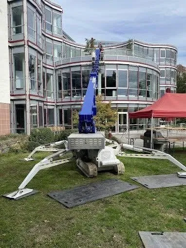 Spinnenlift im Einsatz zur Glasreinigung an einem großen modernen Gebäude